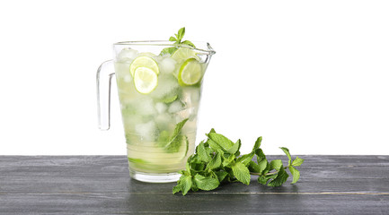 Jug of fresh mojito on table against white background