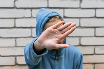 Young girl, teenager covers her face with her hand. Youthful embarrassment, withdrawal from...
