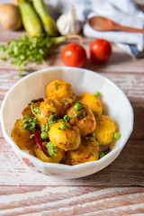 Top view of dum aloo or cooked potatoes along with ingredients