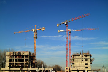 Tower cranes are working on the construction of a new house. Lifting crane.