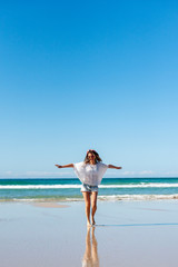 Fototapeta na wymiar Young woman spinning on the beach