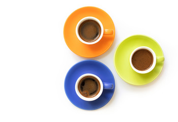 Colored cups of coffee with coffee beans on a white-brown background with copy space.