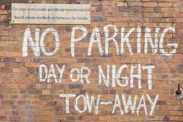 No parking words written on brick wall