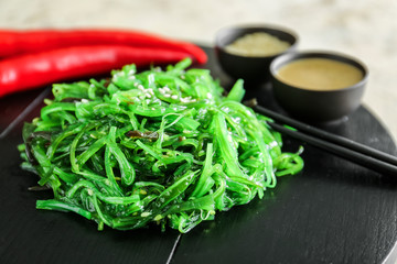 Board with tasty seaweed salad, closeup