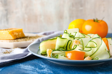 Plate with tasty cucumber salad on table