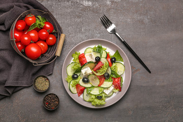 Plate with tasty cucumber salad on dark background