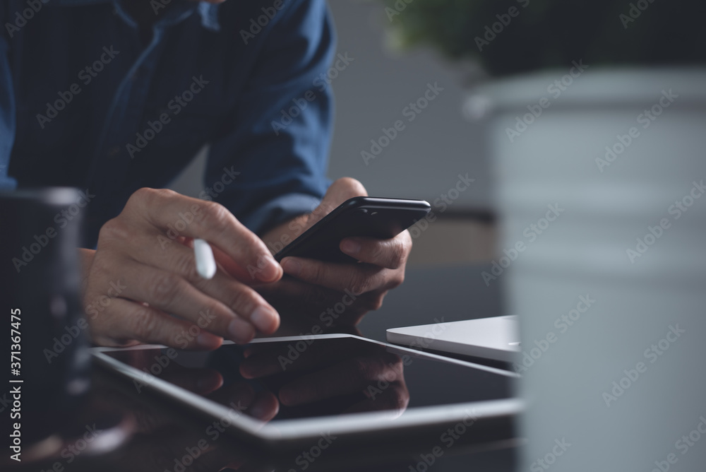 Poster casual business man using mobile phone while online working on computer devices