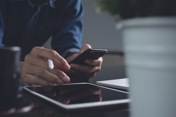 Casual business man using mobile phone while online working on computer devices