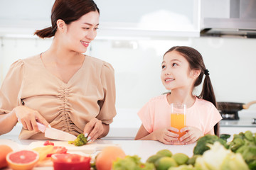 happy Mother and child daughter  preparing the vegetables and fruit in kitchen