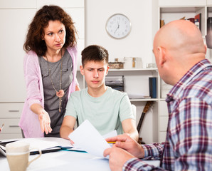 Casual family with teenage son working with papers at home