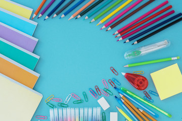 Top view of school supplies lie on light blue background. Back to school concept.