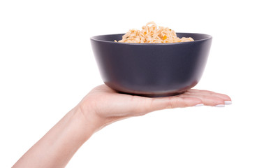 Hand with asian instant noodle in dark bowl, isolated on white background.