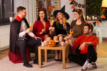 friendship, holiday and people concept - group of happy smiling friends in halloween costumes of...