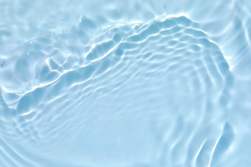 Blurred transparent blue colored clear calm water surface texture with splashes and bubbles. Trendy...