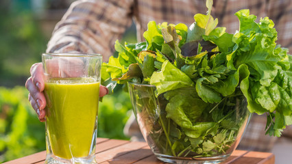 Vitamin drink: A woman puts a plate of lettuce leaves around a glass of green smoothie.