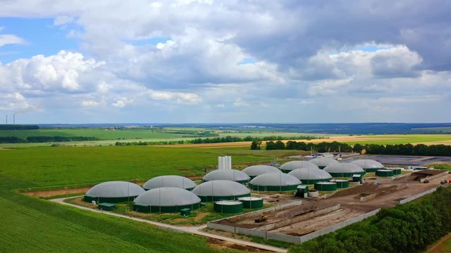Biogas construction. Modern agriculture complex for biomass production on green field. Organic biofuel plant in nature landscape.