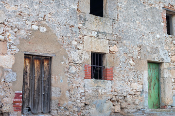 abandoned and dilapidated stone house facade