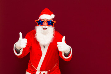 Stylish Santa Claus show give thumb up demonstrate achievement advice solution on red background look at camera