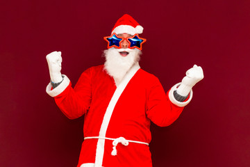 Fototapeta na wymiar Holly jolly x-mas, confidence, magic, triumph concept. Cool funny playful biddle aged man shows win gesture
