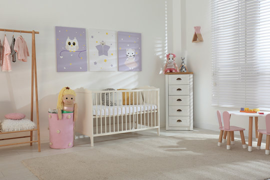 Baby room interior with cute posters and crib