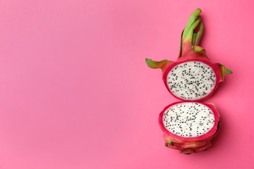Halves of delicious ripe dragon fruit (pitahaya) on pink background, top view. Space for text