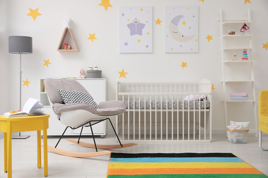 Stylish baby room interior with crib and rocking chair