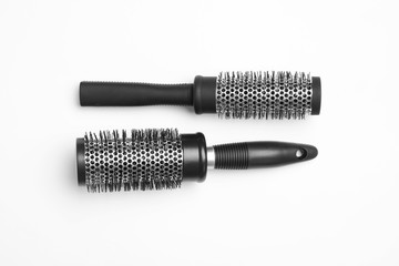 Modern round hair brushes on white background, top view