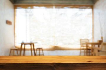Wooden desk space and blurry background of home window for product display montage.
