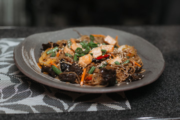 beautiful top view of ready-made dish in a restaurant healthy ingredients fish tuna tomato greens sesame seeds noodles traditional asian cuisine