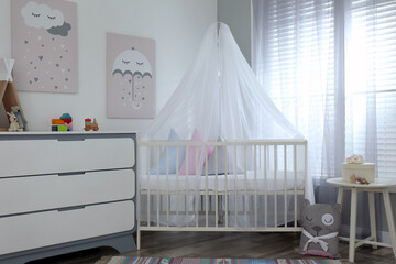 Fototapeta na wymiar Baby room interior with cute posters, chest of drawers and comfortable crib
