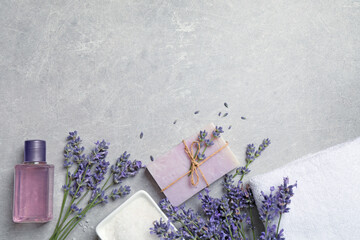Cosmetic products and lavender flowers on light table, flat lay. Space for text