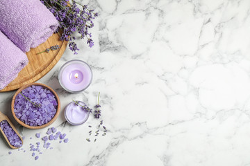 Fototapeta na wymiar Cosmetic products and lavender flowers on white marble table, flat lay. Space for text