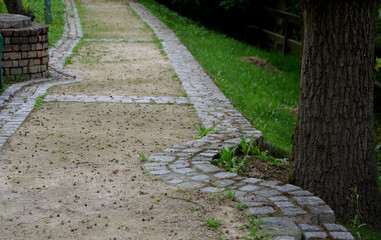 beige threshing path gravel with delimited edges granite cubes in a row and dividing channels from...