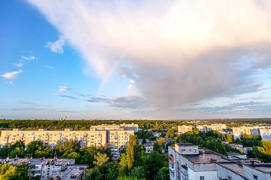 .an incredible rainbow effect over the residential areas of the city after rain in the summer