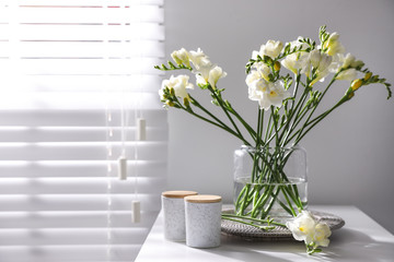 Beautiful spring freesia flowers on table in room