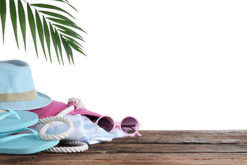 Different beach objects on wooden table against white background. Space for text