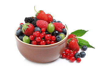 Mix of different fresh berries in bowl on white background