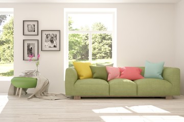 Obraz premium White stylish minimalist room with sofa and summer landscape in window. Scandinavian interior design. 3D illustration