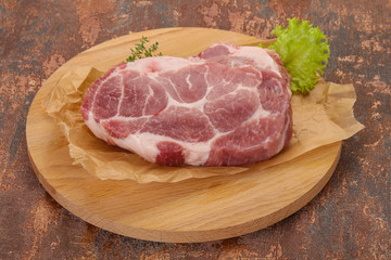 Raw pork steak over wooden board