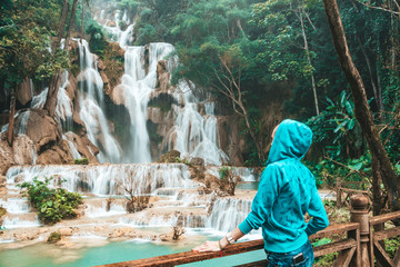 tourist girl enjoy in Kuang Si waterfall, Luang Prabang, Laos. Young woman have fun and happy...