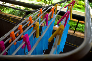 Corona Virus pandemic masks being hanged on a cloth rod after cleaning. Reusable blue colored face masks