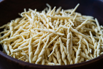 Fresh Trofie Raw Italian Pasta in Wooden Bowl.