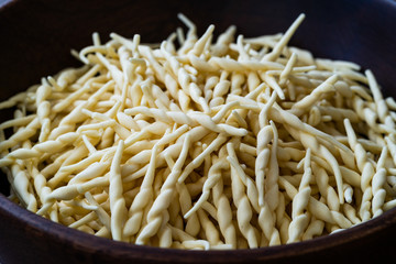 Fresh Trofie Raw Italian Pasta in Wooden Bowl.