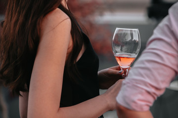 Glass of sparkling rose wine at a summer tasting in the hands of a woman.