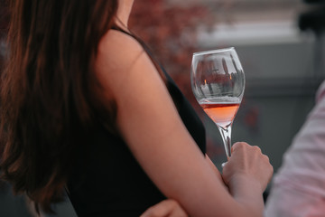 Glass of sparkling rose wine at a summer tasting in the hands of a woman.