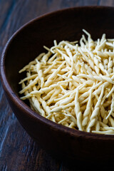 Fresh Trofie Raw Italian Pasta in Wooden Bowl.