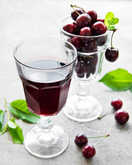 Cherry liqueur in a glass and fresh fruits