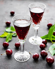 Cherry liqueur in a glass and fresh fruits