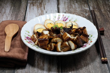 Traditional chopped grilled fresh squid (octopus) and cutting boiled egg topping on cooked jasmine rice. Famous rice street food menu in Asia. Comfort food concept.