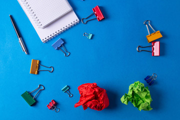 different stationary items and notebooks on the blue background. minimalism. flat lay